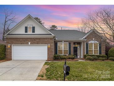 Charming brick home with a well-manicured lawn and attached two-car garage, complemented by a beautiful sunset backdrop at 786 Platinum Dr, Fort Mill, SC 29708