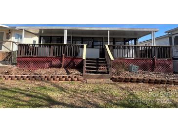 Enclosed back porch with red lattice and access to a covered deck overlooking yard at 103 Dogwood Cir, New London, NC 28127