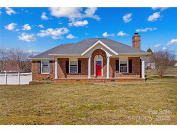 Charming one-story brick home with a welcoming red front door and well-maintained lawn at 130 Ketchie Dr, Mooresville, NC 28115