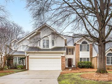 Charming two-story home featuring a brick and gray siding exterior, attached garage and manicured lawn at 2027 Meadowood Ln, Charlotte, NC 28211