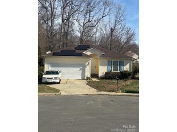 Charming single-story home featuring a driveway, garage, solar panels, and manicured landscaping at 3002 Willamette Valley Dr, Charlotte, NC 28215