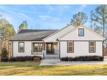 Charming single-story home featuring brick and siding exterior, well-manicured lawn, and inviting entryway at 40934 Deer Haven Dr, Albemarle, NC 28001
