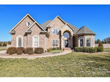 Beautiful brick and stone home with mature landscaping and arched front entry at 4812 Campobello Dr, Monroe, NC 28110