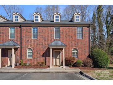Charming multi-story brick townhome featuring dormer windows and well-maintained landscaping at 653 Camrose Ne Cir, Concord, NC 28025