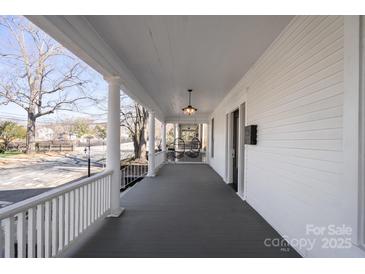 Expansive front porch offers a relaxing outdoor space with classic white railings and a view of the neighborhood at 85 Grove Nw Ave, Concord, NC 28025