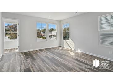 Bright bedroom featuring hard surface flooring, large windows that provide natural light, and neutral paint at 1211 Pine St # A, Mooresville, NC 28115