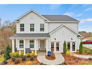 Beautiful two-story home featuring a modern facade, covered porch, and lush landscaping at 18010 Aura Mist Way # 178, Huntersville, NC 28078