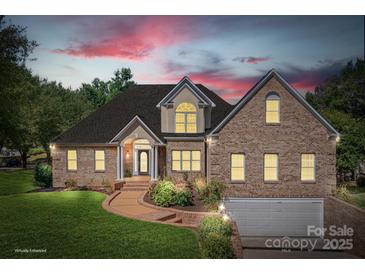 Charming brick home with manicured lawn, beautiful landscaping, and attached two-car garage at 126 Emerald Dr, Mooresville, NC 28117