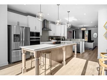 Bright, modern kitchen with a large island, stainless steel appliances, and pendant lighting at 14024 Felix Ln # 4, Charlotte, NC 28277