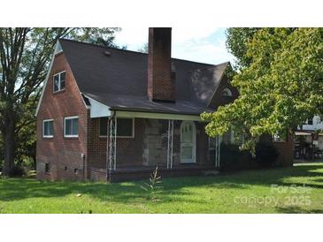 Charming brick home featuring a covered front porch and mature trees at 3045 Woodleaf Rd, Salisbury, NC 28147