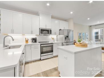 Well-equipped kitchen featuring sleek white cabinets, stainless steel appliances, and an island at 4010 Citra Ln, Charlotte, NC 28217