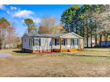 Charming single-story home with gray siding, black shutters, and a cozy front porch at 8670 Carroll St, Hickory, NC 28601