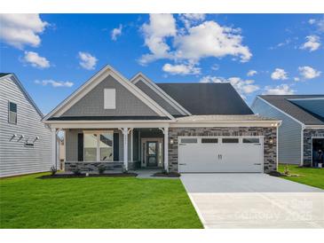 Charming single-story home featuring stone accents, a two-car garage, and a well-maintained lawn at 9096 El Sworth Dr, Sherrills Ford, NC 28673
