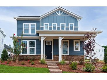 Charming two-story home with blue siding, stone accents, covered porch and manicured front lawn at 9528 Pointer Rd # 63, Huntersville, NC 28078
