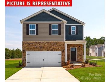 Charming two-story home featuring a brick facade and a two-car garage at 11205 Cardinal Creek Ave, Charlotte, NC 28215