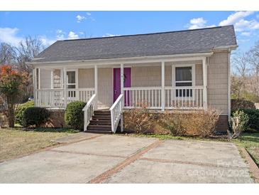Charming home featuring a covered porch, a purple front door, and nicely maintained landscaping at 114 Glen Rae Sw St, Concord, NC 28025