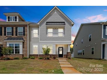 Charming two-story townhome featuring a well-manicured lawn and inviting front entrance at 13044 Cottage Crest Ln, Charlotte, NC 28273