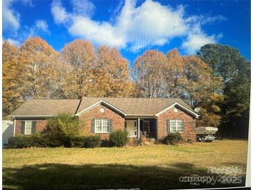 Charming single-story brick home featuring a well-manicured lawn and mature trees in a quiet neighborhood at 14818 Hooks Rd, Matthews, NC 28105