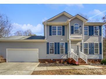 Charming two-story home with blue shutters, vinyl siding, attached garage and landscaped yard at 3450 Seminole Dr, Maiden, NC 28650