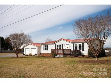 Charming single-story home with a red roof, inviting front porch, and detached garage at 3991 Bunker Hill School Rd, Claremont, NC 28610