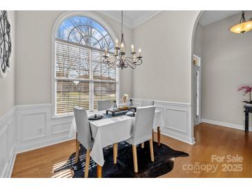 Elegant dining room features a large window and chandelier lighting, perfect for entertaining at 4405 Zee Ct, Monroe, NC 28110