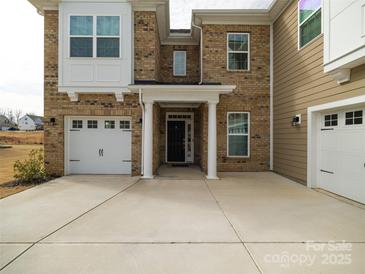 This home's entrance showcases an elegant doorway framed by white pillars and access to attached two-car garage at 611 Yucatan Dr, Waxhaw, NC 28173