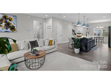 Bright living room showcasing a modern sofa, round coffee table, and open layout into the kitchen at 201 Bennett Trail Dr, Mount Holly, NC 28120