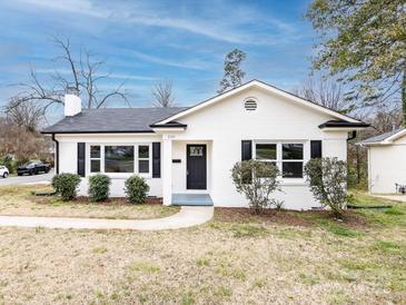 Charming exterior of home featuring a white brick facade, black shutters and door, and manicured landscaping at 2286 Kilborne Dr, Charlotte, NC 28205