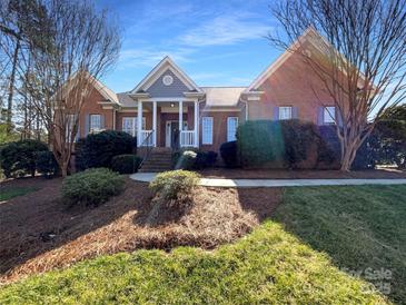 Charming brick home with a welcoming front porch and well-manicured landscaping at 235 Glenville Dr, Fort Mill, SC 29715
