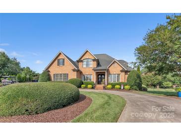 Charming brick home features manicured landscaping, a circular driveway, and a welcoming front entrance at 3759 Sand Wedge Dr, Gastonia, NC 28056