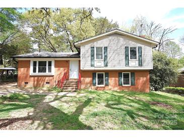 Two story home featuring brick facade and upper level vinyl siding and a front yard at 6126 Eagle Peak Dr, Charlotte, NC 28214