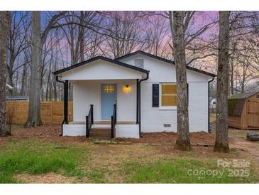 Charming white brick home featuring a blue front door, black trim, and a cozy front porch at 735 Green St, Rock Hill, SC 29730
