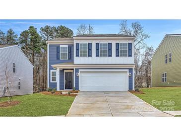 Charming two-story home features a blue and white exterior, attached two-car garage and landscaped yard at 116 Dorian Pl, Troutman, NC 28166