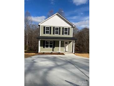 Charming two-story home with green siding, black shutters, and a covered front porch at 1425 Wildwood Dr, Kannapolis, NC 28081