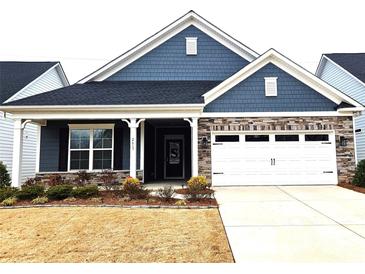 Charming home featuring a stone and shingle facade with a two-car garage and well-manicured landscaping at 2617 Manor Stone Way, Indian Trail, NC 28079
