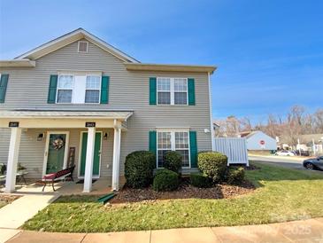 Charming townhouse with green shutters, well-maintained landscaping, and inviting front porch on a sunny day at 2643 Meadow Knoll Dr, Charlotte, NC 28269