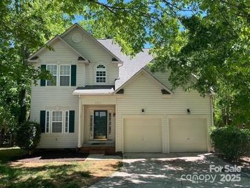 Charming two-story home boasts a two-car garage and a well-maintained front yard with mature trees at 5323 Dewmorn Pl, Charlotte, NC 28269