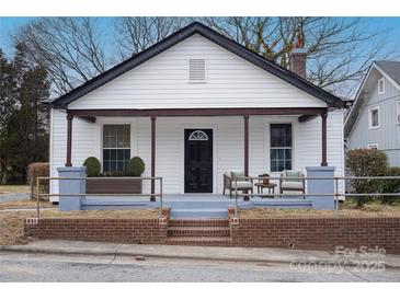 Charming home featuring a welcoming front porch with seating and landscaped accents at 720 Holmes St, Salisbury, NC 28144