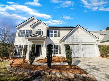 Beautiful two-story home with a two-car garage, black shutters, and professional landscaping at 13903 Mallard Roost Rd, Charlotte, NC 28262
