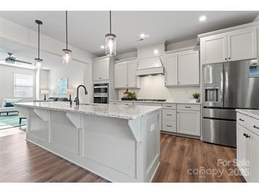 Open-concept kitchen with a large island, stainless steel appliances, and seamless flow to the living room at 1645 Unison Dr, Charlotte, NC 28262
