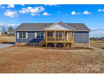 Charming single-story home featuring a covered porch, vinyl siding, and a well-lit exterior at 451 Lookout Dam Rd, Statesville, NC 28625