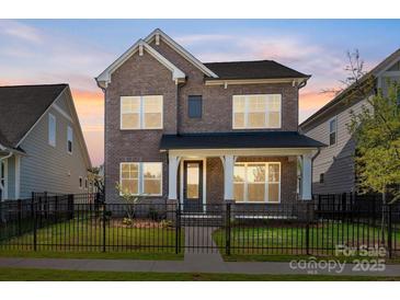 Charming two-story brick home with a fenced front yard and covered porch at 17021 Malone Ln, Mint Hill, NC 28227