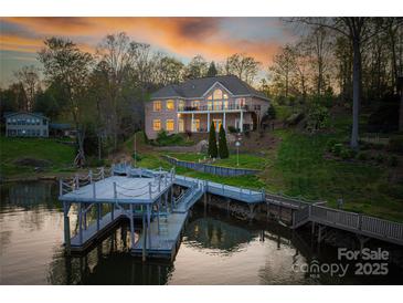 Waterfront home featuring a private dock, meticulous landscaping, and a brick exterior with a balcony overlooking the lake at 4164 54Th Ne Ave, Hickory, NC 28601