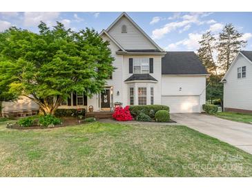 Charming two-story home with a well-manicured front lawn, mature tree, and inviting curb appeal at 10230 Blackstock Rd, Huntersville, NC 28078