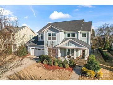 Charming two-story home with a well-manicured lawn, inviting front porch, and a two-car garage at 12018 Grey Partridge Dr, Charlotte, NC 28278