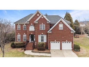 Charming two-story brick home featuring an attached two car garage and manicured landscaping at 13132 Purple Dawn Dr, Charlotte, NC 28213