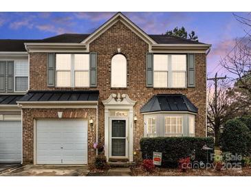 Charming brick home with a two-car garage, manicured landscaping, and a welcoming front porch at 157 Talbert Town Loop, Mooresville, NC 28117