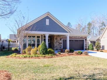 Charming single-story home featuring a well-maintained lawn, stone accents, and an attached two-car garage at 2209 Lincolnshire Ln, Waxhaw, NC 28173