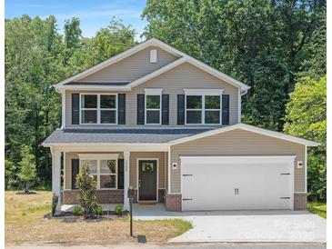 Inviting two-story home with a two-car garage and landscaped front yard surrounded by lush green trees at 222 Ventner Ct, Charlotte, NC 28214