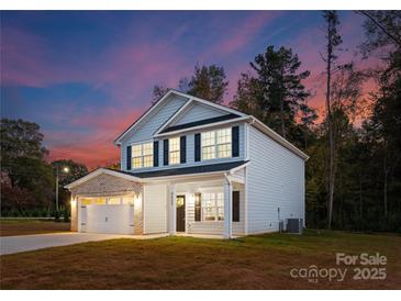 Charming two-story home featuring a covered front porch and attached two-car garage with brick accents at 222 Ventner Ct, Charlotte, NC 28214